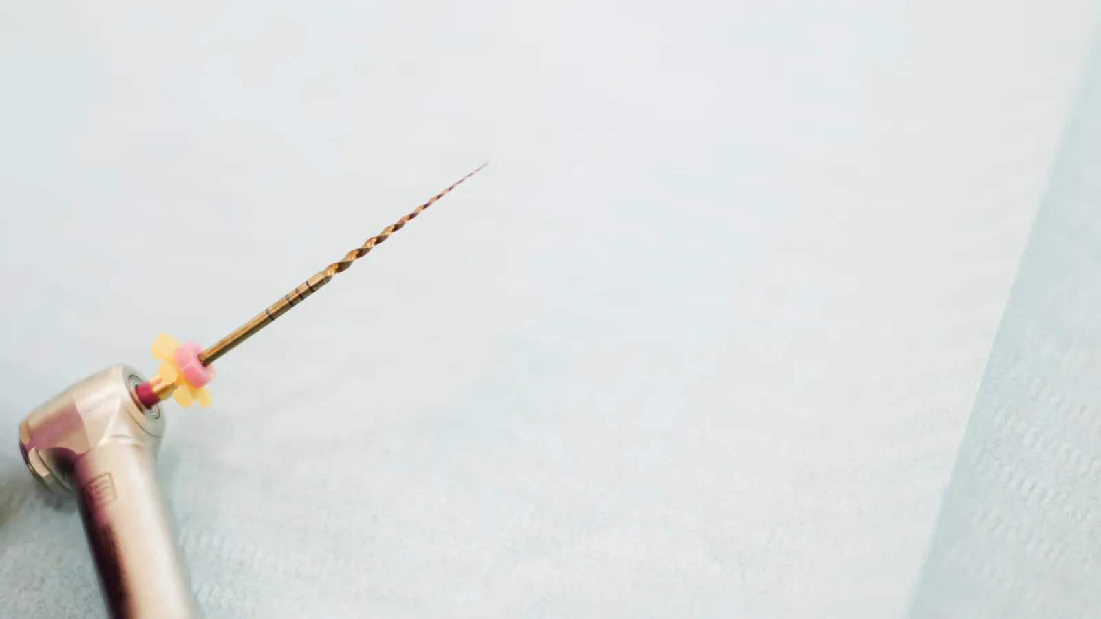 A rotary endodontic file mounted in the handpiece, ready to shape the root canal